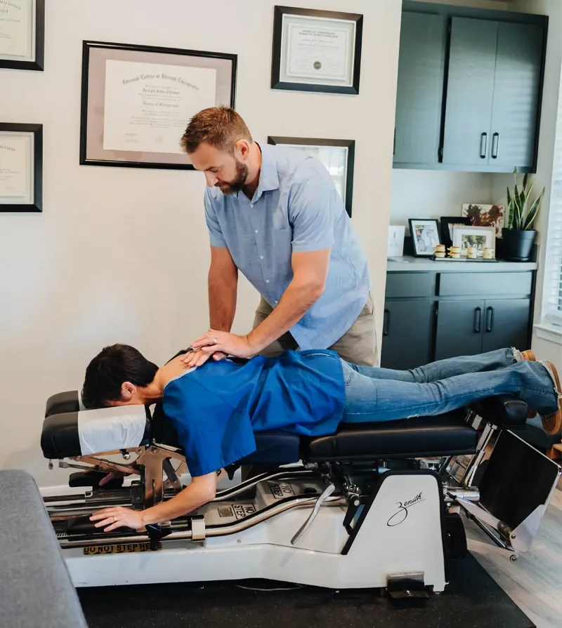 Chiropractor performing a spinal adjustment on a patient