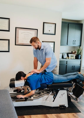 Chiropractor applying a spinal adjustment on a patient lying face down